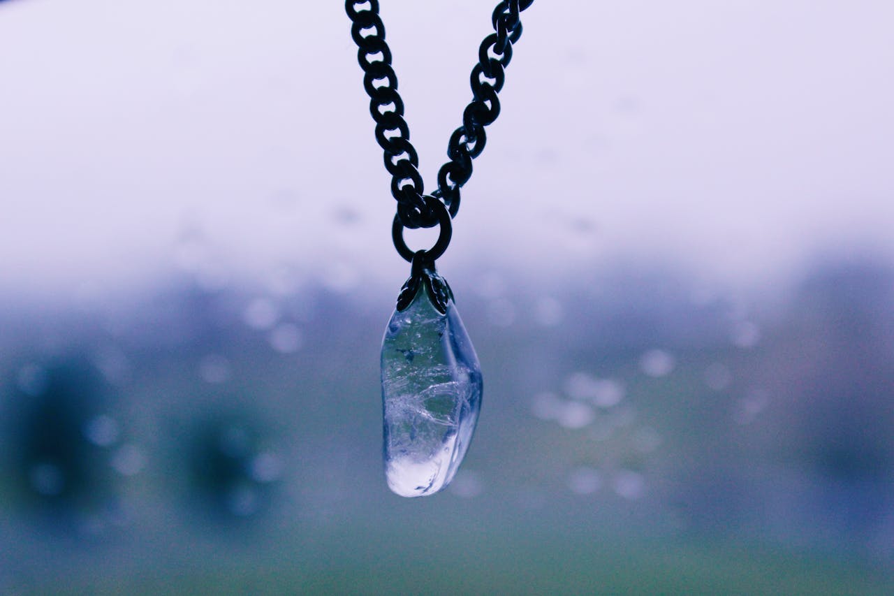 A close-up of a crystal pendant hanging on a chain, perfect for jewelry or fashion themes.